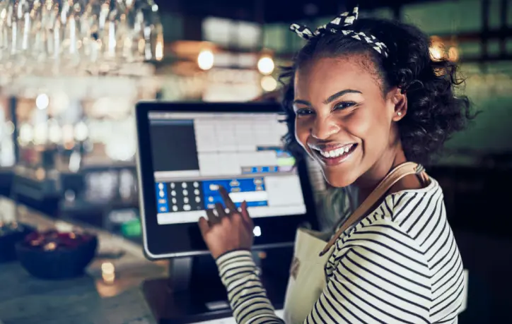 woman-smiling-at-cash-register.webp